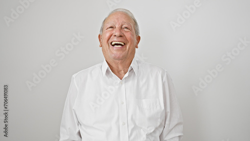 Casual snapshot of a cheerful, smiling senior man, full of confidence and joy, standing against an isolated white background, radiating happiness in his mature lifestyle.