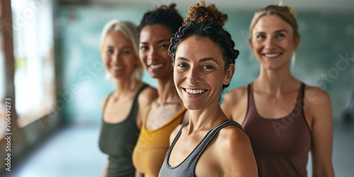 A group of athletic women joyfully posing in a yoga studio.