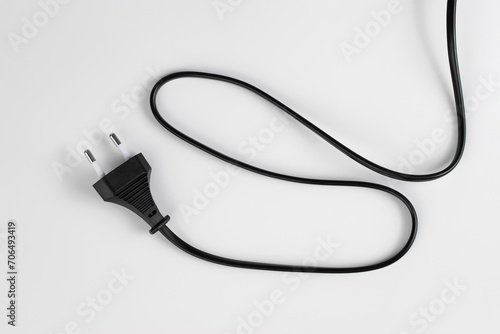 black plastic plug from an electrical appliance with a wire, isolated on a white background