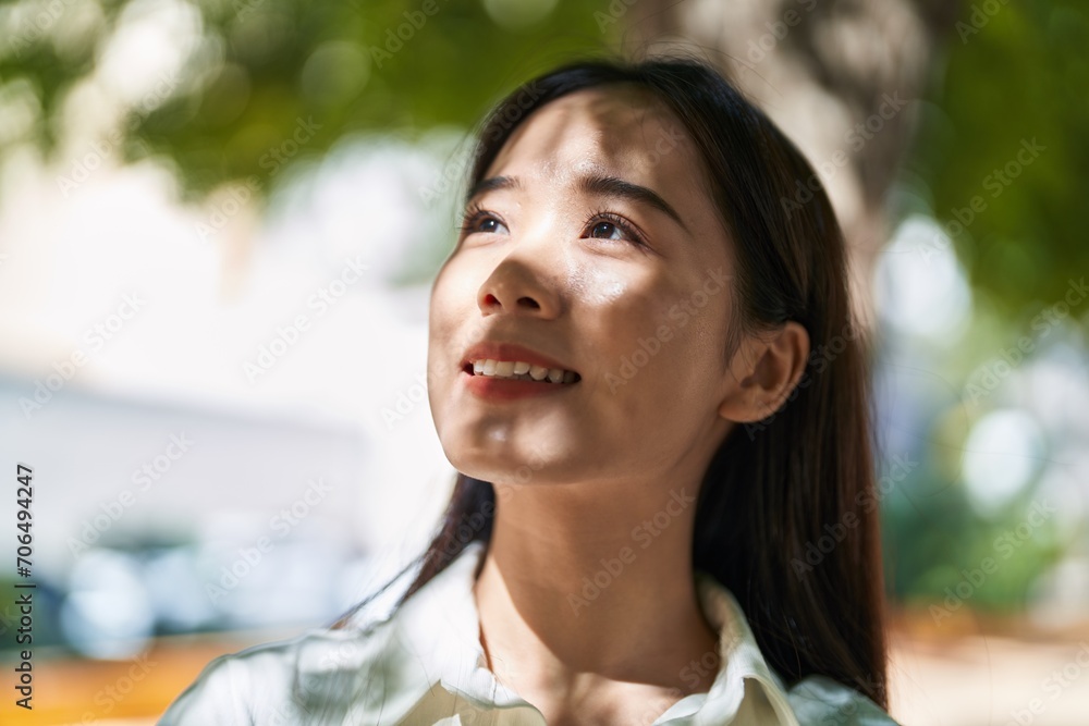 Young chinese woman smiling confident looking to the sky at park Young chinese woman smiling confident looking to the sky at park