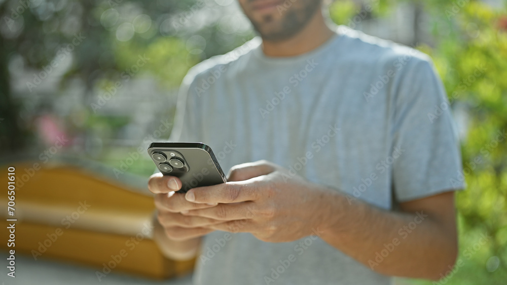Handsome young, blond, bearded man using his smartphone for texting conversation in green city park. adult guy immersed in online communication, holding mobile, deep in digital connection. Handsome young, blond, bearded man using his smartphone for texting conversation in green city park. adult guy immersed in online communication, holding mobile, deep in digital connection.