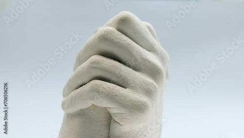 Plaster hands, rotating sculpture of a man and woman's hands 