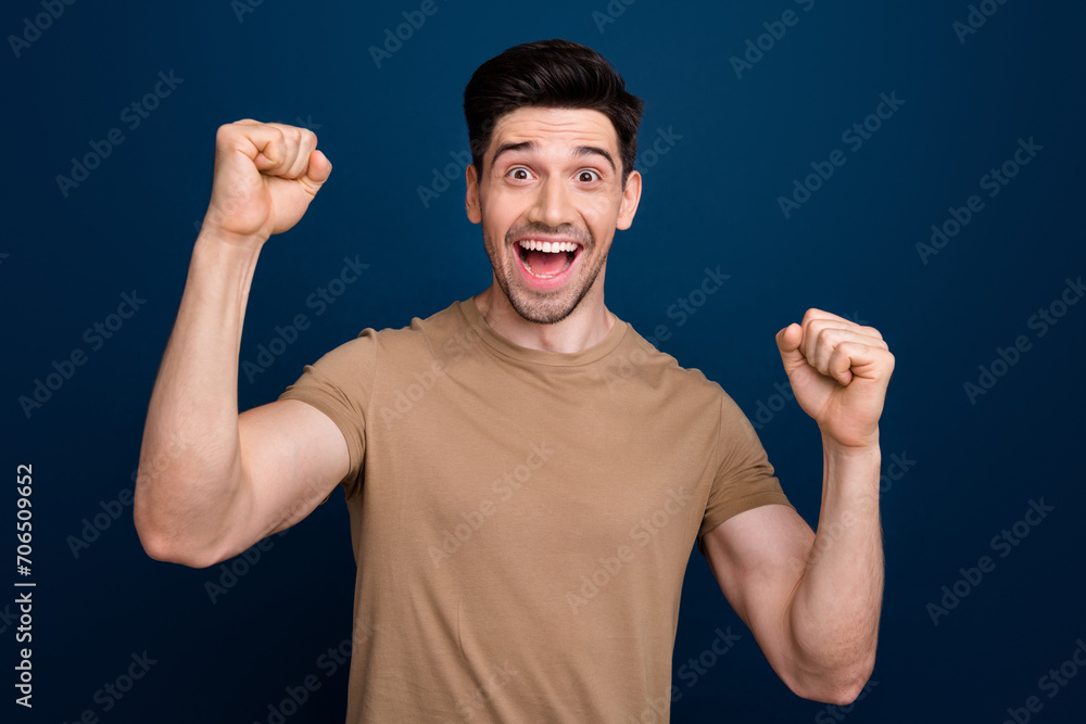 Fototapeta premium Photo of overjoyed cheerful man dressed beige stylish clothes celebrate victory isolated on dark blue color background