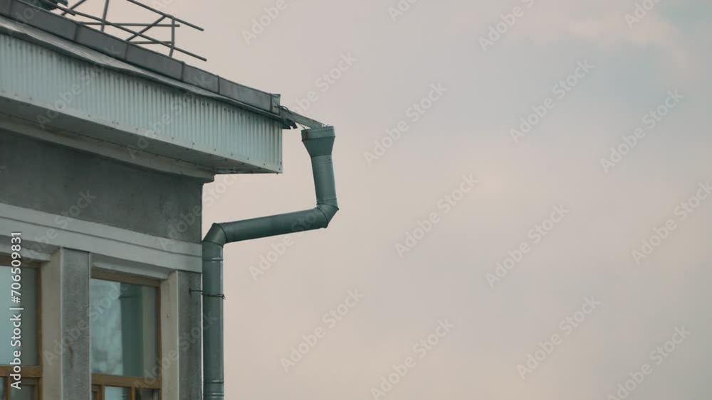 part of a building with a cornice of the roof and a metal downpipe part of a building with a cornice of the roof and a metal downpipe