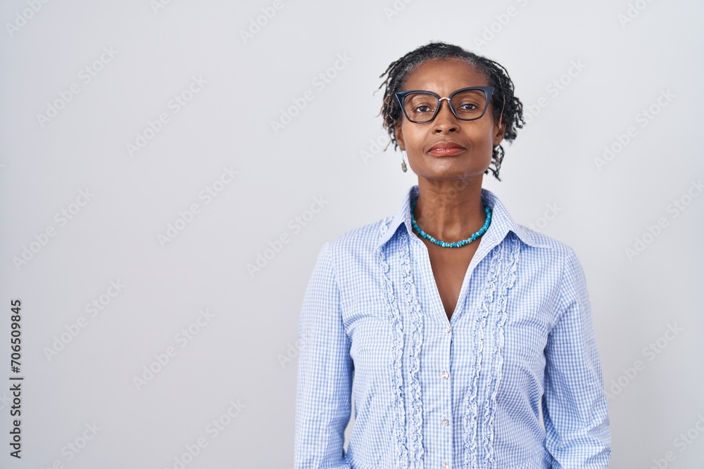 African woman with dreadlocks standing over white background wearing glasses relaxed with serious expression on face. simple and natural looking at the camera. African woman with dreadlocks standing over white background wearing glasses relaxed with serious expression on face. simple and natural looking at the camera.