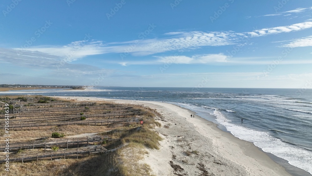 Coastline of Pawleys Island in South Carolina South of Myrtle Beach with beach houses, vacation rental real estate by Atlantic Ocean under blue sky in early morning with sunshine