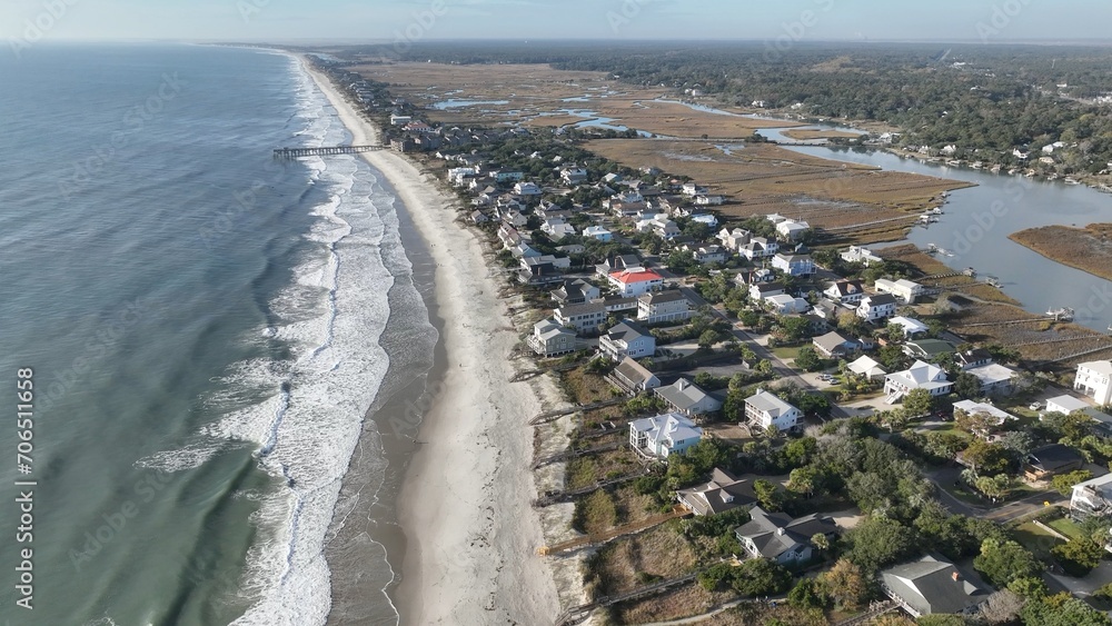 Coastline of Pawleys Island in South Carolina South of Myrtle Beach with beach houses, vacation rental real estate by Atlantic Ocean under blue sky in early morning with sunshine