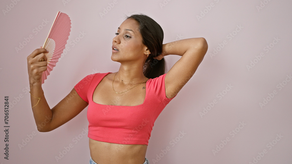 Young latin woman using handfan suffering for hot over isolated pink background Young latin woman using handfan suffering for hot over isolated pink background