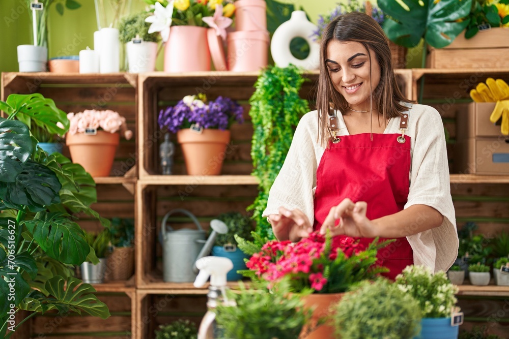 Young beautiful hispanic woman florist smiling confident touching plant at flower shop Young beautiful hispanic woman florist smiling confident touching plant at flower shop