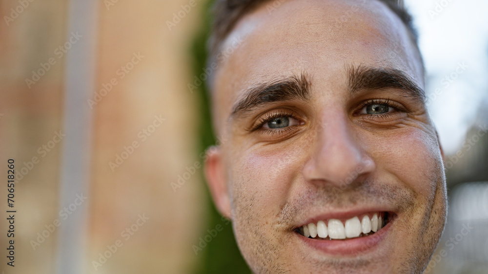 Close-up of a cheerful young hispanic man outdoors with an urban background, portraying casual, modern masculinity. Close-up of a cheerful young hispanic man outdoors with an urban background, portraying casual, modern masculinity.