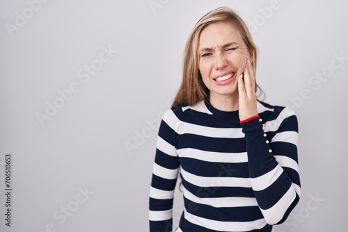 Photos Young caucasian woman wearing casual navy sweater touching mouth with hand with painful expression because of toothache or dental illness on teeth