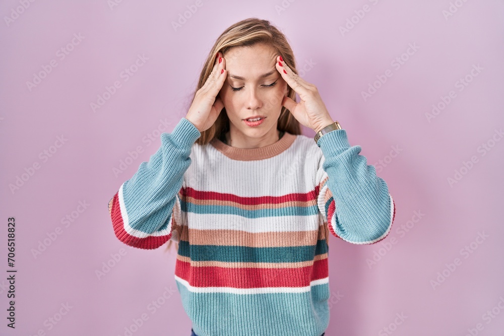 Young blonde woman standing over pink background with hand on head, headache because stress. suffering migraine. Young blonde woman standing over pink background with hand on head, headache because stress. suffering migraine.