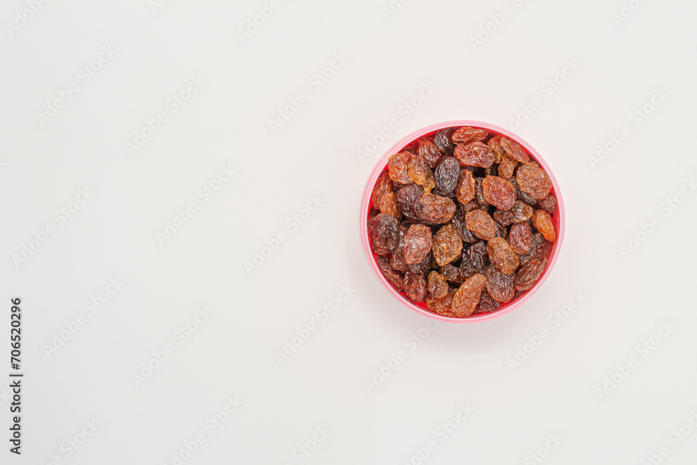 Obraz premium Raisins in a bowl on a white background, with copy space. Macro image. Healthy snack.