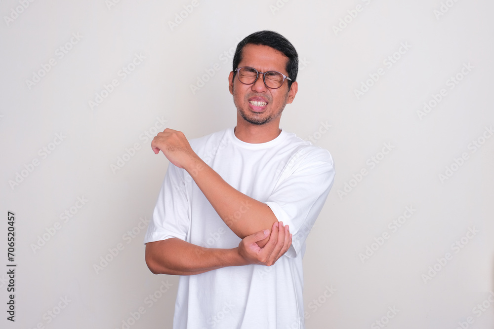 Adult Asian man suffering elbow pain Adult Asian man suffering elbow pain