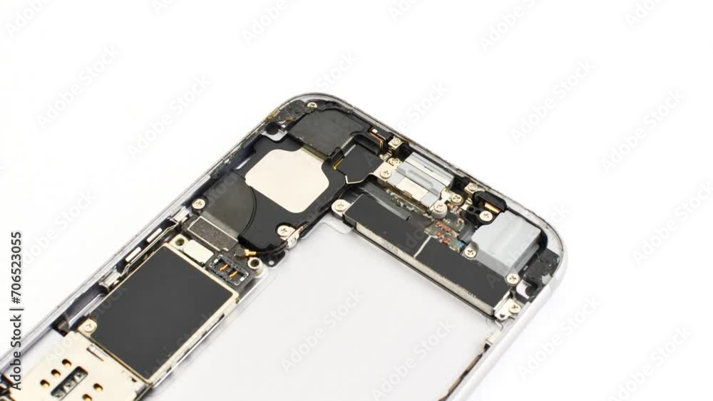 Open smartphone under maintenance on a white surface, revealing its internal complexity. Close view of a disassembled phone for maintenance on a white base, exposing its inner structure. Open smartphone under maintenance on a white surface, revealing its internal complexity. Close view of a disassembled phone for maintenance on a white base, exposing its inner structure.