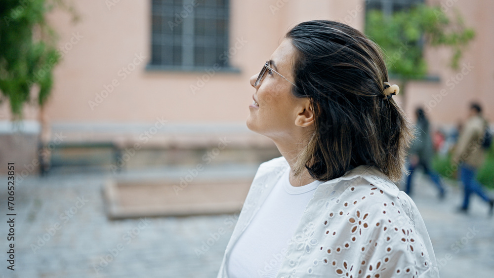 Beautiful young hispanic woman smiling confident looking to the side in the streets of Stockholm Beautiful young hispanic woman smiling confident looking to the side in the streets of Stockholm