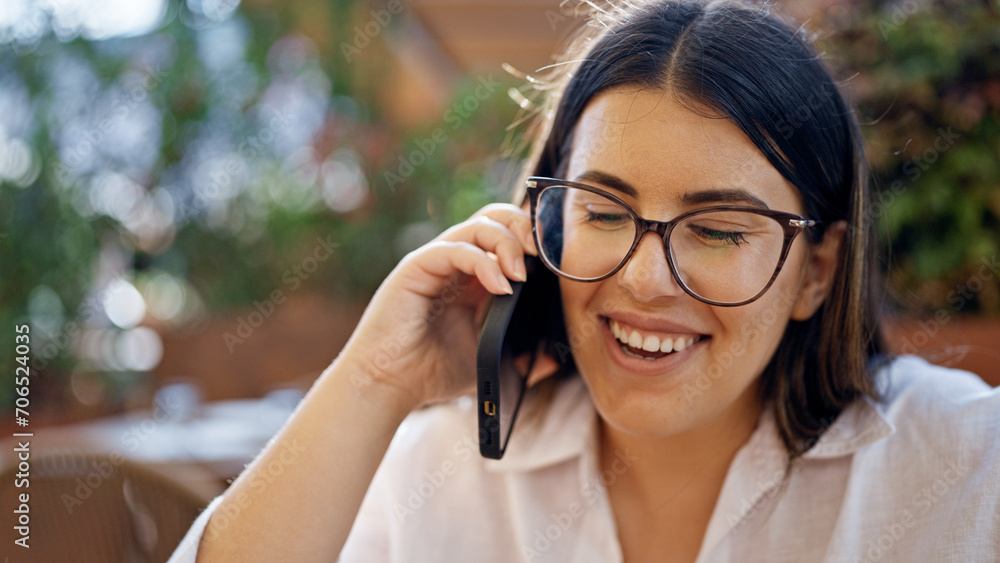 Young beautiful hispanic woman smiling happy speaking on the phone sitting on the table at bar terrace Young beautiful hispanic woman smiling happy speaking on the phone sitting on the table at bar terrace