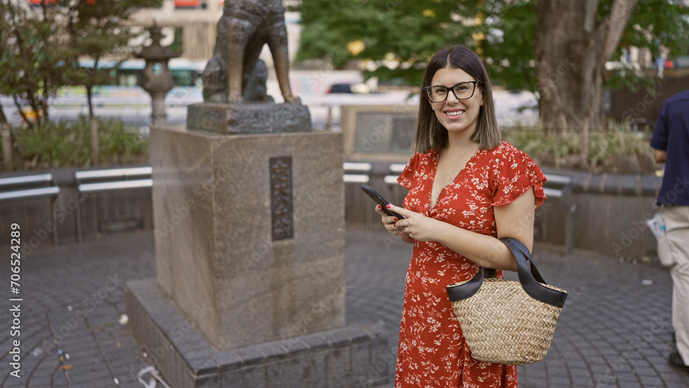 Stunningly beautiful hispanic woman in glasses, standing by iconic hachiko statue on bustling tokyo street, capturing the japanese urban expression of loyalty, culture and travel