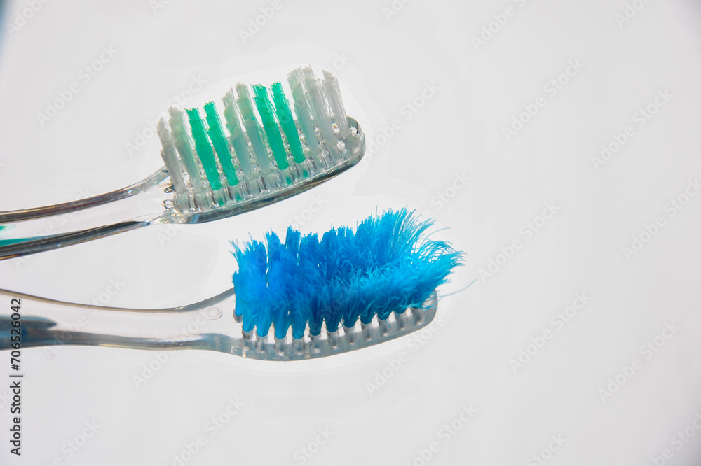 old and new toothbrush on a light background. hygiene rules concept. old and new toothbrush on a light background. hygiene rules concept.