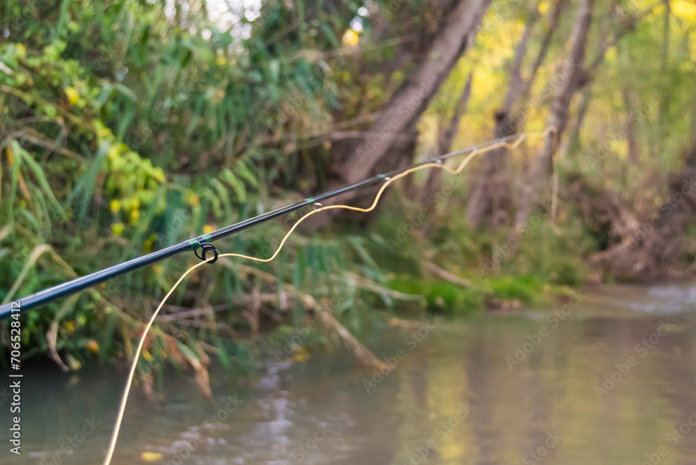 fishing rod with a yellow line cast in the river fishing rod with a yellow line cast in the river
