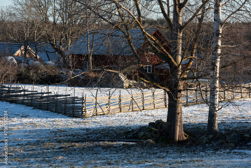 Winter scenery in a Swedish village with fences and red wooden buildings