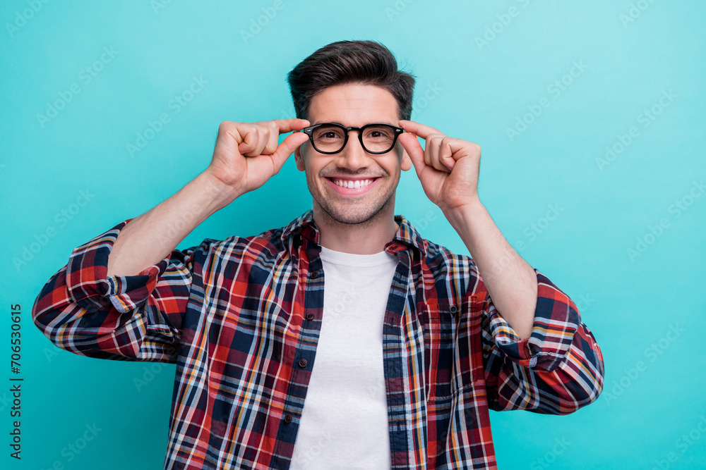 Photo of cheerful smart man dressed plaid shirt arms eyewear smiling isolated turquoise color background Photo of cheerful smart man dressed plaid shirt arms eyewear smiling isolated turquoise color background