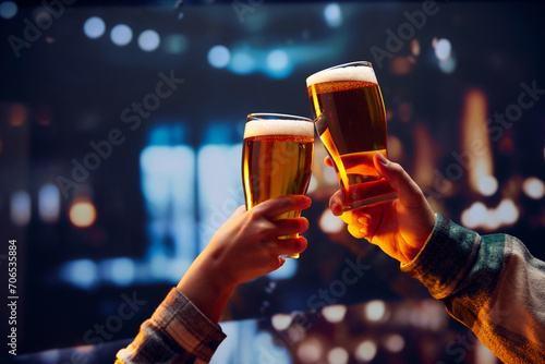 Fotografie Hands holding big mug of lager light foamy beer and clinking