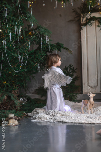 boy in white with wings in Christmas studio