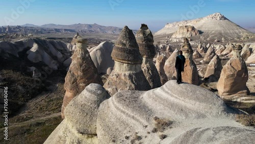 Aerial drone view of a person admiring the natural beauty of Pasabag Valley or Monks Valley and  Fairy Chimneys In Cappadocia, Turkey. Famous destination for hikers to explore the Rock Sites.