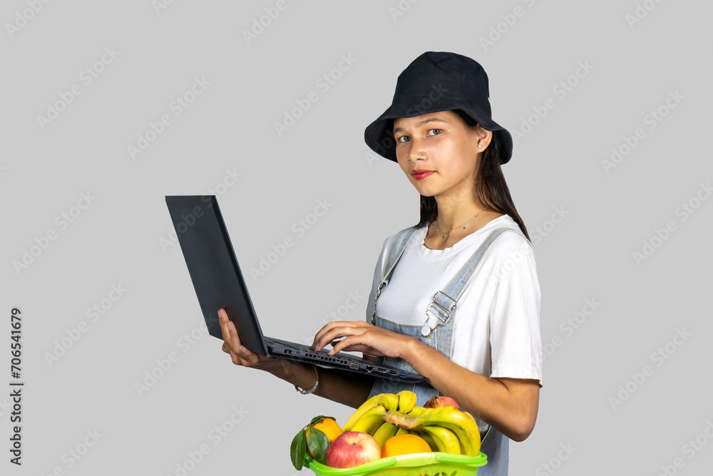 A farmer entrepreneur girl with fruits and vegetables using technology laptop and giving expressions and gestures A farmer entrepreneur girl with fruits and vegetables using technology laptop and giving expressions and gestures