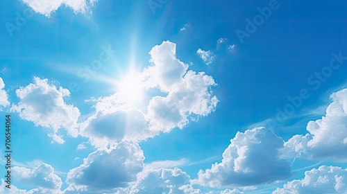 Close-up view of a fluffy cloud in a clear blue sky, with the sun's rays softly shining through it