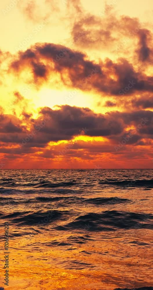 Tropical color cloudscape sunrise over calm sea waves and sun rays through the clouds vertical panorama 4k video Tropical color cloudscape sunrise over calm sea waves and sun rays through the clouds vertical panorama 4k video