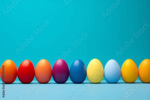 Colorful painted Easter eggs stand in a row on a blue background witn copy space, space for text. Banner to advertise Easter products or event. Spring festival, bright colors.