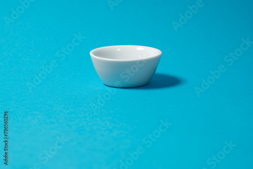 small white bowl isolated on turquoise background