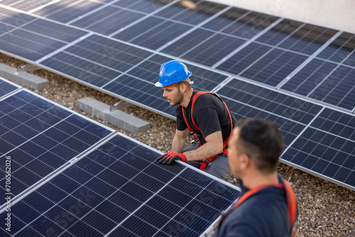 Construction workers installing solar panels on a rooftop