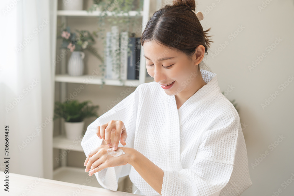 Health care, beauty smile pretty asian young woman in bathrobe, towel after shower bath at home, finger applying moisturizer on her back hand. Skin body cream moisturizing lotion, routine in morning. Health care, beauty smile pretty asian young woman in bathrobe, towel after shower bath at home, finger applying moisturizer on her back hand. Skin body cream moisturizing lotion, routine in morning.