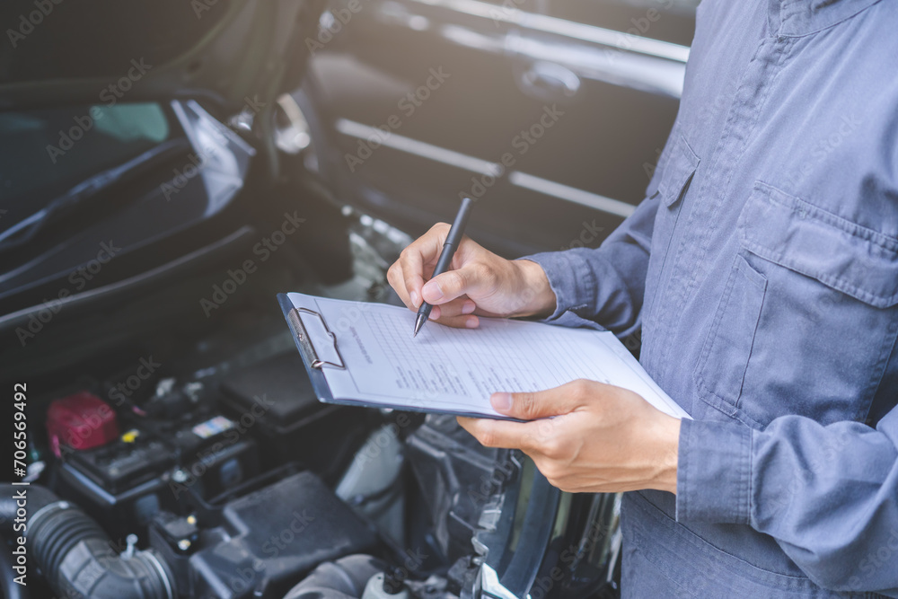 Auto check, car service shop concept. Automobile repairman writing job checklist on clipboard, mechanic checking engine to estimate repair machine, inspecting maintenance by engineer at vehicle garage - obrazy, fototapety, plakaty 