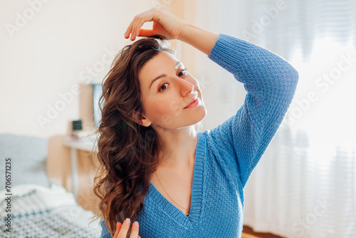 Canvastavla Portrait of woman checks her hair after heatless hair curler at home