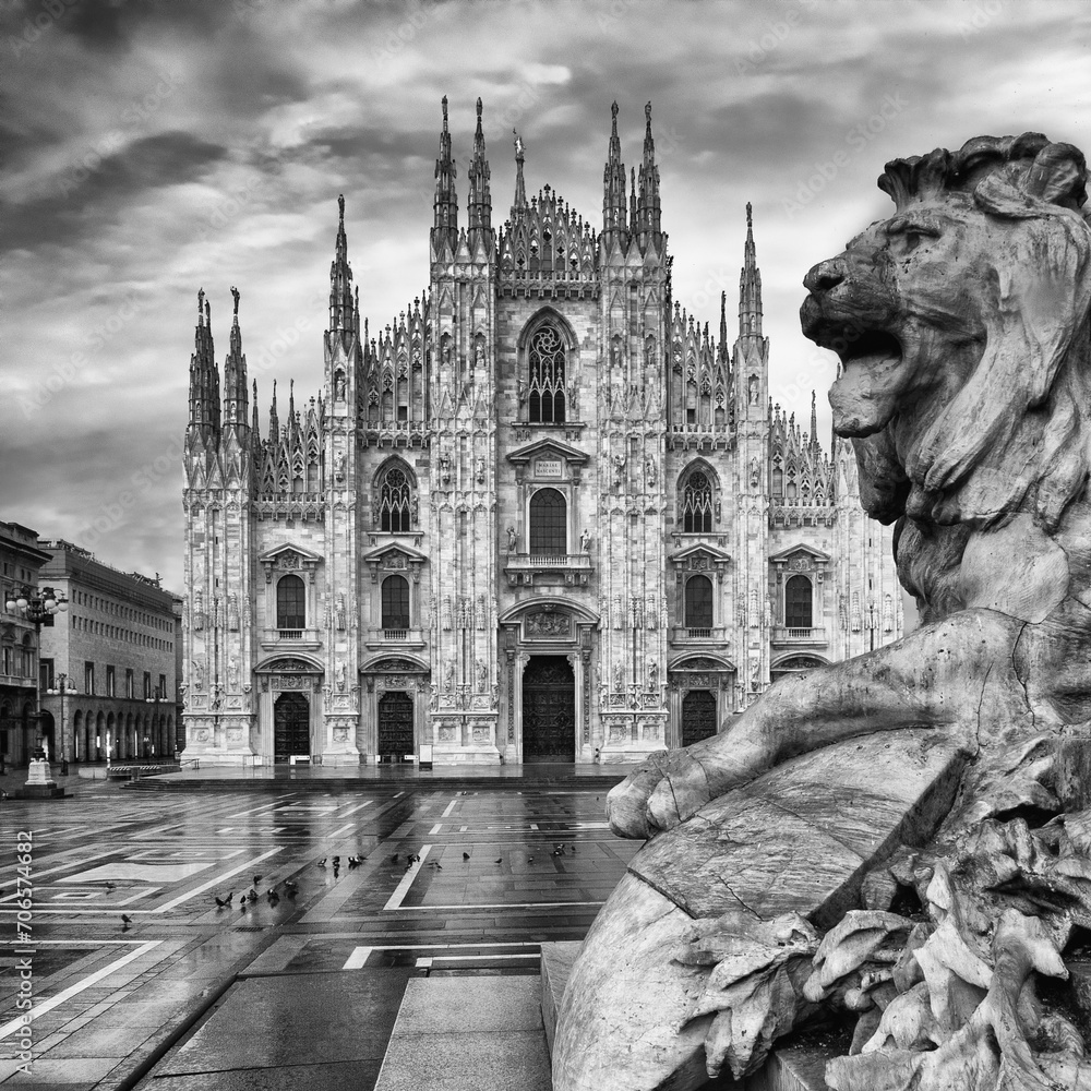 black and white photo of a lion statue in front of a cathedral