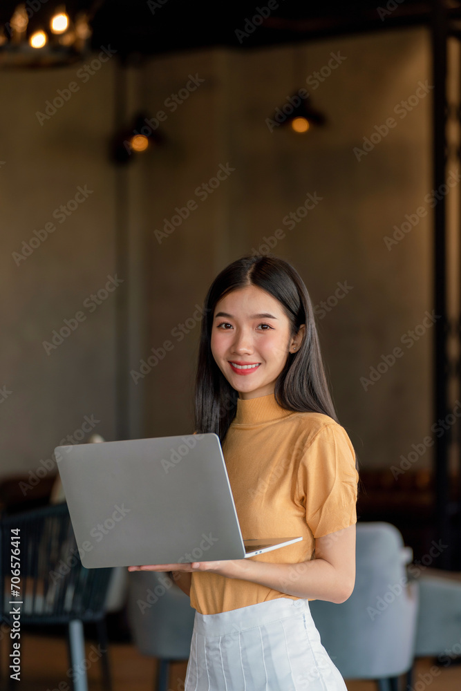 Young asian woman working on laptop at a remote workplace Young asian woman working on laptop at a remote workplace