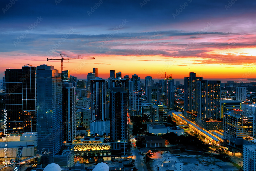 Aerial View of Miami City at Sunset From Building Top. Behold the breathtaking beauty of Miami City bathed in the warm hues of a sunset from the vantage point of a towering building.