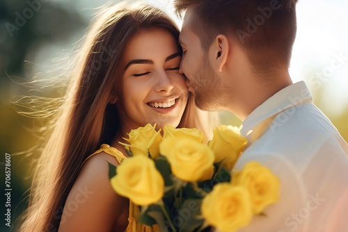 A happy young girl in the arms of her beloved boyfriend with a bouquet of yellow roses. A romantic couple expressing their feelings outside on a sunny summer day. Bouquet of flowers