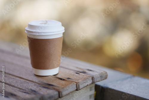 Take away hot drink coffee brown paper cup with isolated blurry background