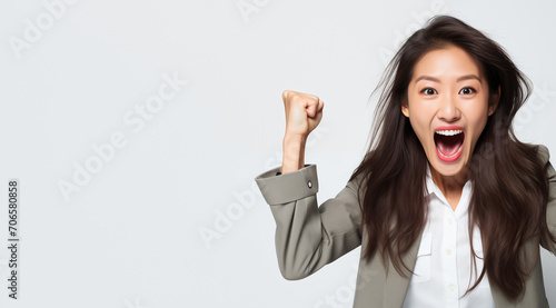Femme asiatique jeune, heureuse, souriante, bras levés, poings serrés, arrière-plan blanc, image avec espace pour texte