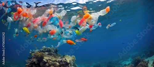 Plastic and algae float above the coral reef in the Red Sea, while tropical fish feed below. © AkuAku