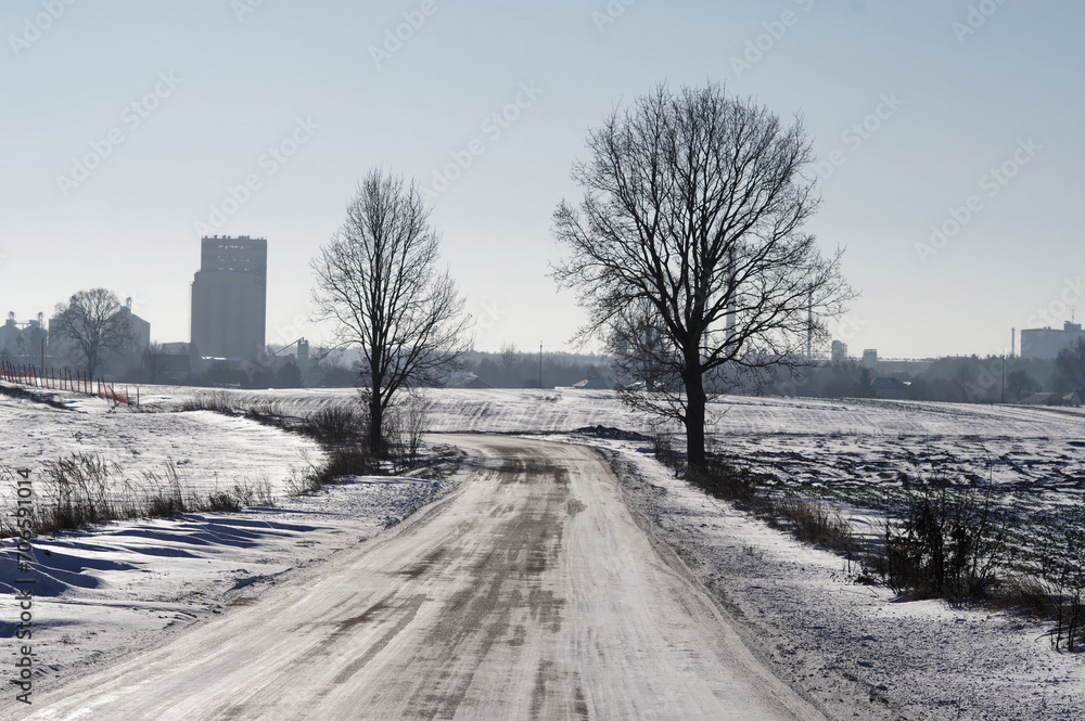 Krajobraz zimowy, droga ośnieżona i oblodzona.
