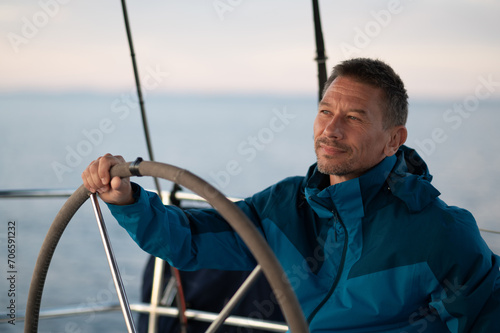 Good-looking mature man sailing a yacht and looking confident © zinkevych