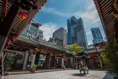Singapore, Singapore - September 21, 2022: The Thian Hock Keng Temple in Singapore, dedicated to both Buddhism and Taoism, contrasts with the modern towers of the business district. photo