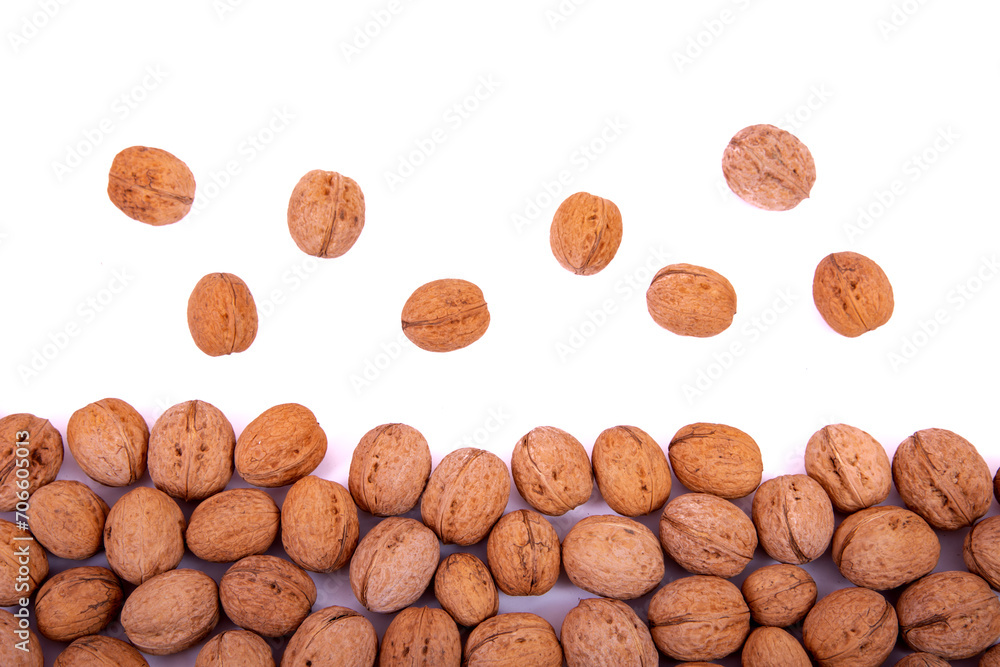 Scattered whole walnuts lie on a white background. Backgrounds and textures. Isolate. Scattered whole walnuts lie on a white background. Backgrounds and textures. Isolate.