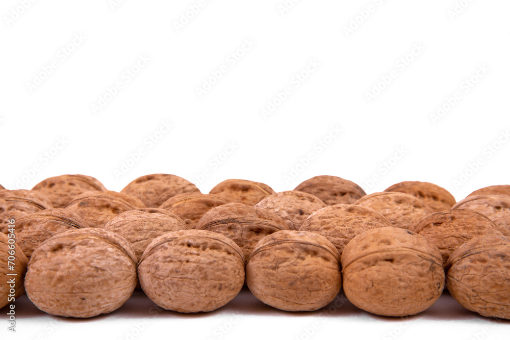 Scattered whole walnuts lie on a white background. Backgrounds and textures. Isolate. Scattered whole walnuts lie on a white background. Backgrounds and textures. Isolate.